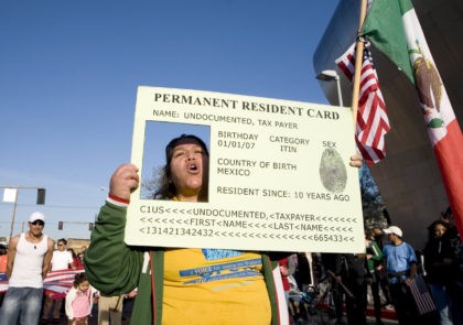 Josephine Corral of Tacoma, Washington, puts her head through a large green card replica during a May Day march May 1, 2008 in Seattle, Washington. The four-mile march drew thousands of people and clogged traffic in downtown Seattle during rush hour. (Photo by Stephen Brashear/Getty Images)