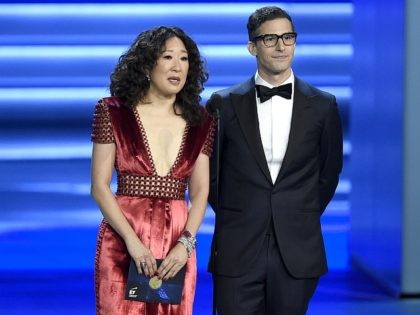 FILE - In this Sept. 17, 2018 file photo, Sandra Oh, left, and Andy Samberg present an award at the 70th Primetime Emmy Awards in Los Angeles. Oh and Samberg will share host duties at next month’s Golden Globe ceremony. (Photo by Chris Pizzello/Invision/AP, File)