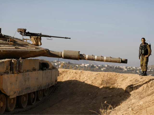 A picture taken on November 16, 2017, shows Israeli Army officer Lt. Col Elad Efrati battalion commander standing next to a tank at an army position overlooking southern Lebanon in the northern Israeli town of Metula, along Israel's border with Lebanon. / AFP PHOTO / MENAHEM KAHANA (Photo credit should …