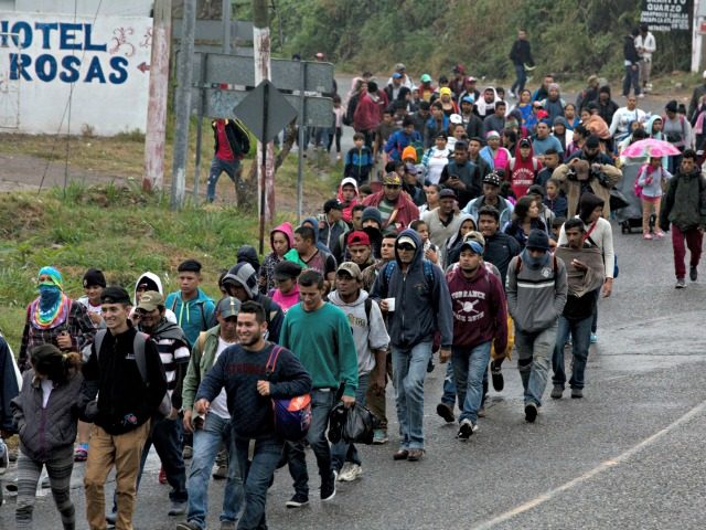 Honduran migrants walk along the roadside through Esquipulas, Guatemala, as they make thei