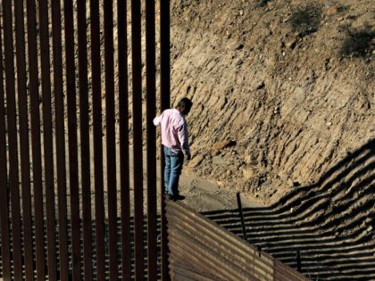 A migrant near the border fence between Tijuana, Mexico, and San Diego. President Trump ha