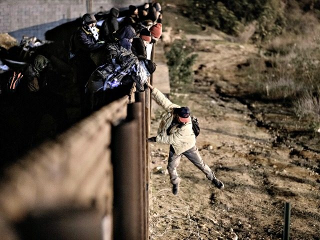 A migrant jumps the border fence to get into the U.S. side to San Diego, Calif., from Tijuana, Mexico, Tuesday, Jan. 1, 2019. Discouraged by the long wait to apply for asylum through official ports of entry, many migrants from recent caravans are choosing to cross the U.S. border wall …