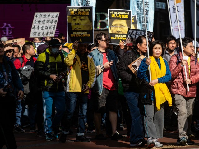 Protesters display placards of former chief executive Leung Chun-ying (centre L) and curre