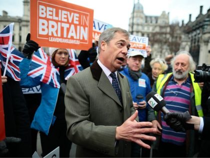 LONDON, ENGLAND - JANUARY 15: Crowds hold pro-Brexit signs and Union Jack flags near former UKIP Leader Nigel Farage speaking to the media in Parliament Square outside the Palace of Westminster on January 15, 2019 in London, England. MPs vote on Theresa May’s Brexit deal as it finally reaches the …