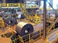 Nucor New rolls of sheet steel exit the spooling machine, and head off to cool down at the NUCOR Steel Gallatin plant, Wednesday, July 25, 2018, in Ghent, Ky. The plant, one of the largest sheet steel manufacturers in the US, has been operating 24 hours a day, seven days a …