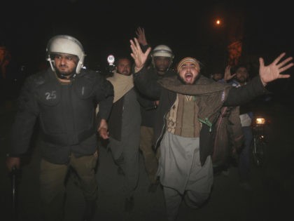 Pakistani police officers arrest a man at a protest against the acquittal of Asia Bibi, a