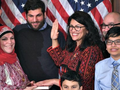 US House Representative Rashida Tlaib (D-MI), wearing a traditional Palestinian robe, takes the oath of office on Thomas Jefferson's English translated Quran, with family members present in a ceremonial swearing-in from Speaker of the House Nancy Pelosi (D-CA) (out of frame) at the start of the 116th Congress at the …