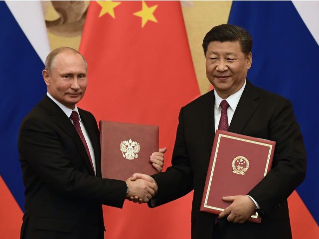 Chinese President Xi Jinping (R) congratulates Russian President Vladimir Putin after presenting him with the Friendship Medal in the Great Hall of the People on June 8, 2018 in Beijing, China.