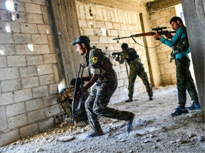 Members of the Syrian Democratic Forces fire their arms during a battle against Islamic State (IS) group jihadists to retake the central hospital of Raqa on the western frontline of the city on September 28, 2017. Syrian fighters backed by US special forces are battling to clear the last remaining …