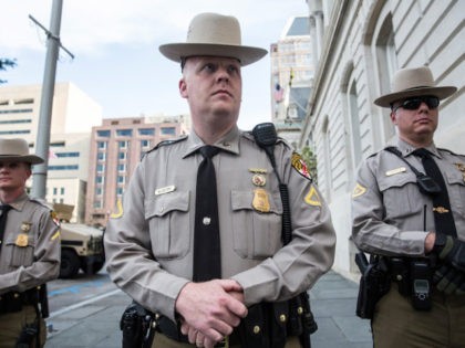 Law enforcement officials stand guard over Baltimore city hall while students from Baltimore colleges and high schools march in protest chanting 'Justice for Freddie Gray' on April 29, 2015 in Baltimore, Maryland.