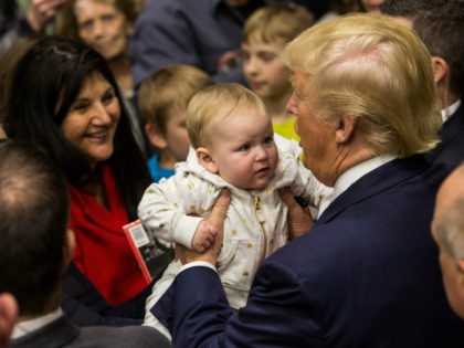 Republican presidential hopeful Donald Trump holds a baby the end of a rally at Great Bay