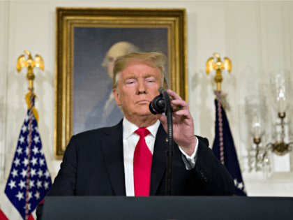 President Donald Trump adjusts the microphone to speak about the partial government shutdown, immigration and border security in the Diplomatic Reception Room of the White House, in Washington, Saturday, Jan. 19, 2019.