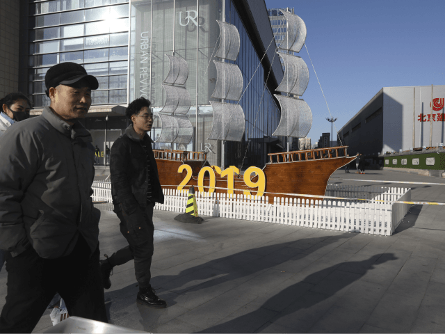 In this Friday, Jan. 4, 2019, photo, Chinese residents pass by a decor marking the new year outside a shopping mall in Beijing. A U.S. delegation led by deputy U.S. trade representative, Jeffrey D. Gerrish arrived in the Chinese capital ahead of trade talks with China. China sounded a positive …