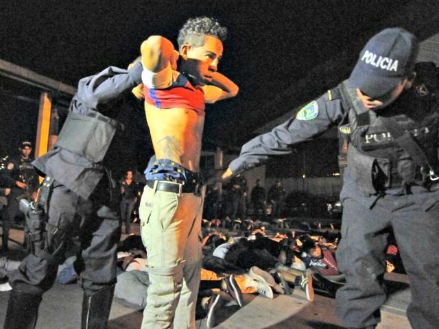 Honduran policemen frisk a young man belonging to the Olympia club’s Ultrafiel fans grou