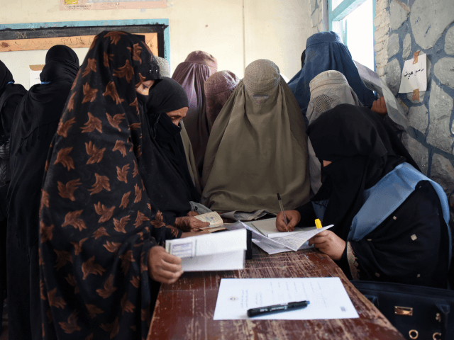 An Afghan Independent Election Commission (IEC) official (R) prepares ballot papers for vo