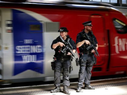 TOPSHOT - Armed British Transport Police Specialist Operations officers patrol on the platform before boarding a Virgin train to Birmingham New Street, at Euston station in London. For the first time, asof May 25, 2017, specially trained firearms officers will be patrolling on board trains as part of threat level …