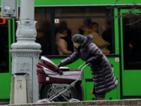 A mother carries a baby carriage as Italian and Belarus flags wave in central Minsk on November 30, 2009. Italian Prime Minister Silvio Berlusconi arrived in Belarus on Monday, making the first visit by a Western leader in 15 years to the country once dubbed 'Europe's last dictatorship.' AFP PHOTO …