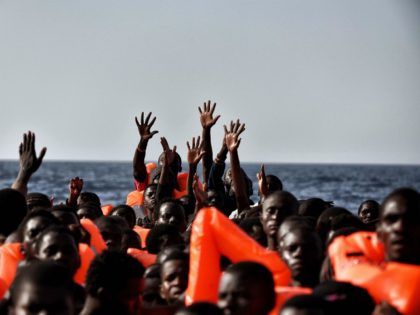 TOPSHOT - Migrants wait to be rescued as they drift in the Mediterranean Sea some 20 nautical miles north off the coast of Libya on October 3, 2016. Italy coordinated the rescue of more than 5,600 migrants off Libya, three years to the day after 366 people died in a …