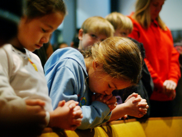 Susan (no last names released) bows her head in prayer as she and fellow fourth-grader Carolyne (L) attend a prayer service to give thanks that no one has died since a car plowed into 12 children, including Vanessa, and three teachers the day before at Westminster Academy Christian Day School, January 31, 2002, in Eagle Rock near Los Angeles, CA. 65-year-old Kae Hak In of Glendale, at the school to pick up her grandchild, apparently put her foot on the gas pedal instead of the brake and her car lurched into the crowd of children. A group of seventh-and eighth-graders on the the Arcadia Christian School basketball team helped a group of adults pick up the car to extracate four or five people before firefighters arrived. (Photo by David McNew/Getty Images)