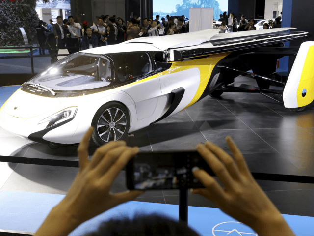 A visitor takes a photo of the Aeromobil, a flying car from Slovakia, during the China Int