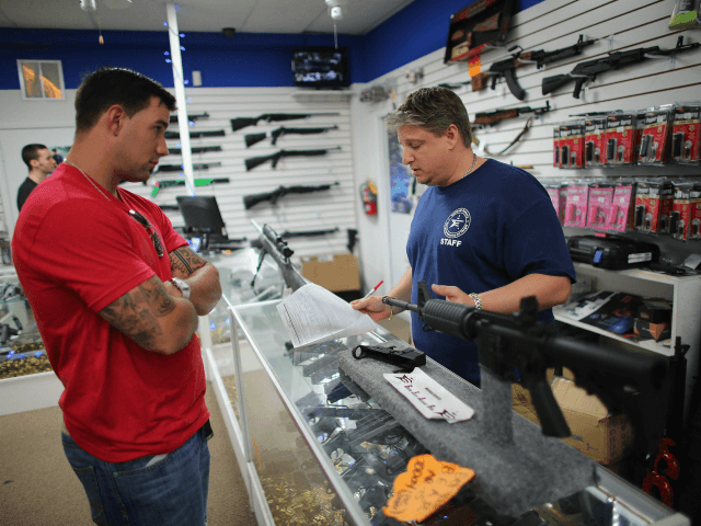 POMPANO BEACH, FL - JANUARY 16: Jonathan Schwartz (R), a salesman at the National Armory gun store, fills out the paperwork for Reese Magnant as he buys a National Armory AR-15 Battle Entry Assault Rife on January 16, 2013 in Pompano Beach, Florida. President Barack Obama today in Washington, DC …