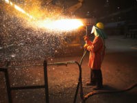 indiana-us-steel-mill-worker-18-afp PORTAGE, IN - MARCH 15: A worker trims a newly-cast steel slab at the NLMK Indiana steel mill on March 15, 2018 in Portage, Indiana. The mill, which is projected to produce up to 1 million tons of steel from recycled scrap in 2018, is considered a "mini mill" by …