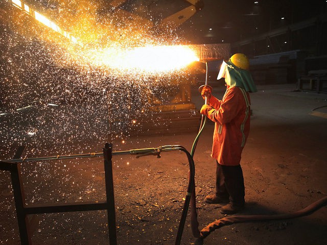PORTAGE, IN - MARCH 15: A worker trims a newly-cast steel slab at the NLMK Indiana steel m