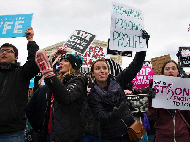 Pro-life activists wave for others to join as they demonstrate in front of the US Supreme