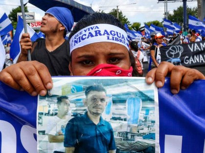 CORRECTS BYLINE - A protestor holds a photo of one of the victims of the deadly protests during an anti-government march in Managua, Nicaragua, Saturday, Aug. 11, 2018. The current unrest began in April, when President Daniel Ortega imposed cuts to the social security system and small protests by senior …