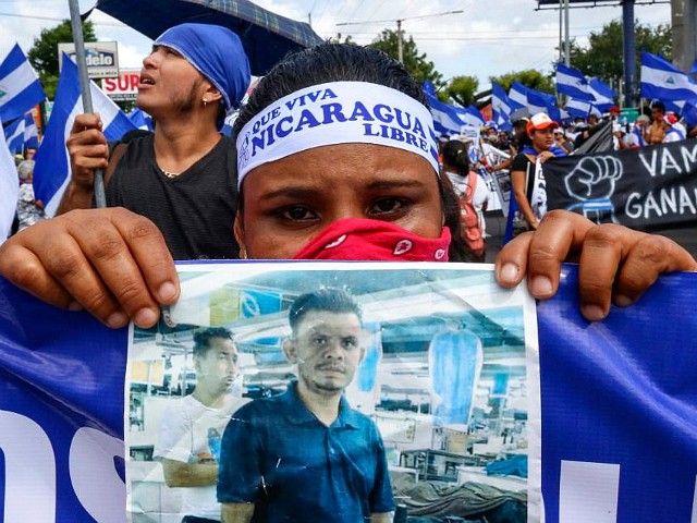 CORRECTS BYLINE - A protestor holds a photo of one of the victims of the deadly protests during an anti-government march in Managua, Nicaragua, Saturday, Aug. 11, 2018. The current unrest began in April, when President Daniel Ortega imposed cuts to the social security system and small protests by senior citizens were violently broken up. From then more than 300 persons have died and demonstrators have demanded that Ortega leave power. (AP Photo/Alfredo Zuniga)