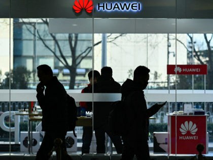 Pedestrians walk past a Huawei store in Beijing on December 28, 2018. - Chinese telecoms g
