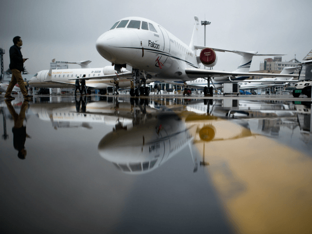 A man passes the Dassault Falcon 2000EX business jet before the start of the 2017 Asian Business Aviation Conference and Exhibition (ABACE) at Shanghai's Hongqiao Airport on April 10, 2017. ABACE will be held at Shanghai Hongqiao Airport from April 11 to 13. / AFP PHOTO / Johannes EISELE (Photo …