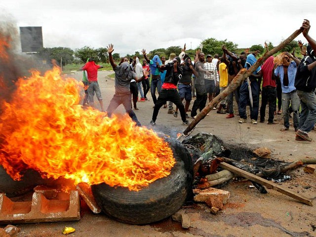 FILE - In this Tuesday, Jan. 15, 2019 file photo, protestors gather near a burning tire du