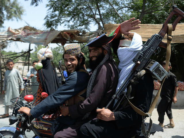 Afghan Taliban militants ride a motorbike as they took to the street to celebrate ceasefire on the second day of Eid in the outskirts of Jalalabad on June 16, 2018. - Taliban fighters and Afghan security forces hugged and took selfies with each other in restive eastern Afghanistan on June …