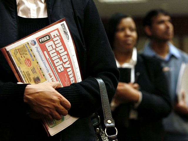 Sonja Jackson, of Detroit, holds a Employment Guide standing in line while attending a job fair in Livonia, Mich., Wednesday, Nov. 4, 2009. The number of newly laid-off workers filing claims for unemployment benefits last week fell to the lowest level in 10 months, evidence that job cuts are easing …