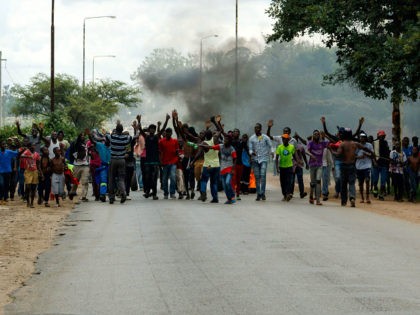 Angry protesters gesture as they block the main route to Zimbabwe's capital Harare from Epworth township on January 14 2019 after announced a more than hundred percent hike in fuel prices. - Angry protesters barricaded roads with burning tyres and rocks in Zimbabwe on January 14 after the government more …