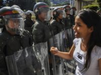 National guard members seen in Caracas as supporters of opposition leader Juan Guaido hand out leaflets offering amnesty to members of the military who defect to his camp US goes after Venezuela's oil to hit Maduro
