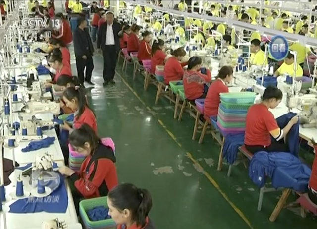 In this file image from undated video footage run by China's CCTV via AP Video, Muslim trainees work in a garment factory at the Hotan Vocational Education and Training Center in Hotan, Xinjiang, northwest China. A U.S. company that stocks college bookstores with t-shirts and other team apparel cut ties …