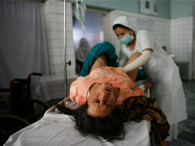 An Afghan mother grimaces as a nurse checks her after a difficult delivery outside the operation room at the Malalai Maternity hospital October 14, 2007 in Kabul, Afghanistan. According to a UNICEF survey, one in nine Afghan women die during or shortly after pregnancy in Afghanistan, this remains is one …