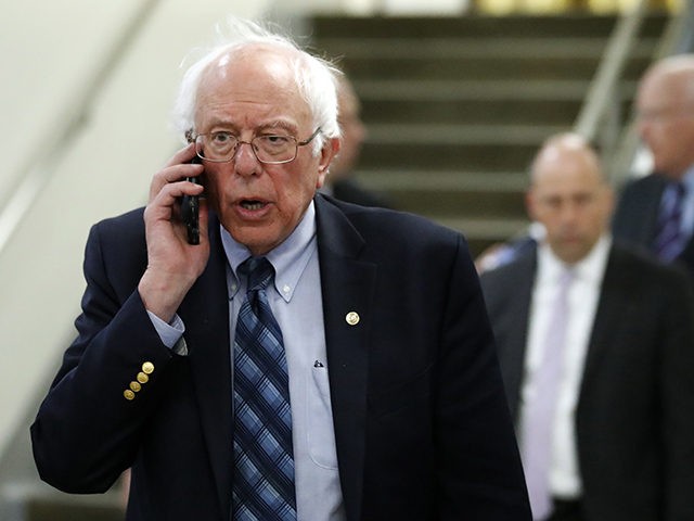 Sen. Bernie Sanders, I-Vt., talks on his phone as he departs after a vote on Gina Haspel t