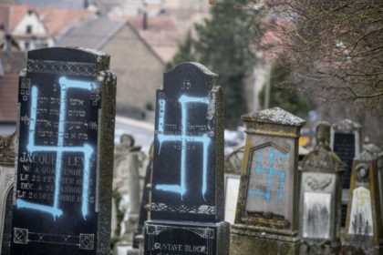 Vandalized tombs with tagged swastikas are pictured in the Jewish cemetery of Quatzenheim, eastern France, Tuesday, Feb.19, 2019. Marches and gatherings against anti-Semitism are taking place across France following a series of anti-Semitic acts that shocked the country. (AP Photo/Jean-Francois Badias)