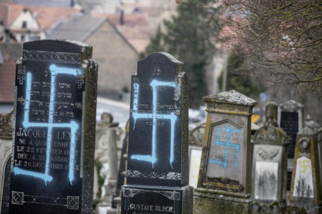 Vandalized tombs with tagged swastikas are pictured in the Jewish cemetery of Quatzenheim,