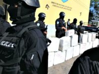 Confiscated Cocaine Police officers from the anti-drug squad in Tegucigalpa on October 7, 2010 look after a load of 500 kilos of cocaine seized from traffickers during a joint operation by the Honduran Police, the Army and the US Drug Enforcement Administration (DEA), in Brus Laguna, Mosquitia, Honduras. AFP PHOTO/Orlando SIERRA