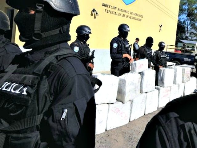 Police officers from the anti-drug squad in Tegucigalpa on October 7, 2010 look after a load of 500 kilos of cocaine seized from traffickers during a joint operation by the Honduran Police, the Army and the US Drug Enforcement Administration (DEA), in Brus Laguna, Mosquitia, Honduras. AFP PHOTO/Orlando SIERRA