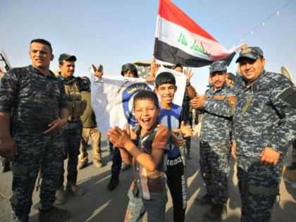 Iraqi federal police members and civilians celebrate in the Old City of Mosul on 9 July 2017 after the government's announcement of the "liberation" of the embattled city. Iraqi Prime Minister Haider al-Abadi's office said he was in "liberated" Mosul to congratulate "the heroic fighters and the Iraqi people on …