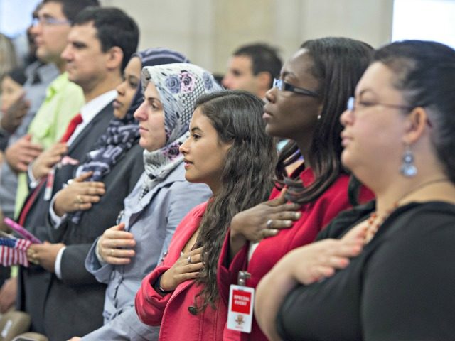 People recite the Pledge of Allegiance during a Naturalization Ceremony at the Justice Department in Washington, DC. Photograph by Saul Loeb—AFP/Getty Images