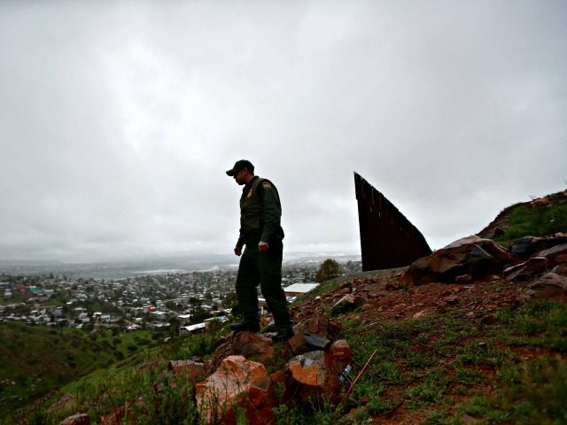 Border Patrol agent Vincent Pirro looks on near where a border wall ends that separates the cities of Tijuana, Mexico, left, and San Diego, Tuesday, Feb. 5, 2019, in San Diego. President Donald Trump is expected to speak about funding for a wall along the U.S.-Mexico border during his State …