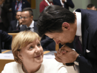 GettyImages-1052455578 TOPSHOT - German Chancellor Angela Merkel (L) has her hand kissed by Italy's Prime Minister Giuseppe Conte (R) ahead of an Asia Europe Meeting (ASEM) at the European Council in Brussels on October 18, 2018. (Photo by JOHN THYS / AFP) (Photo credit should read JOHN THYS/AFP/Getty Images)