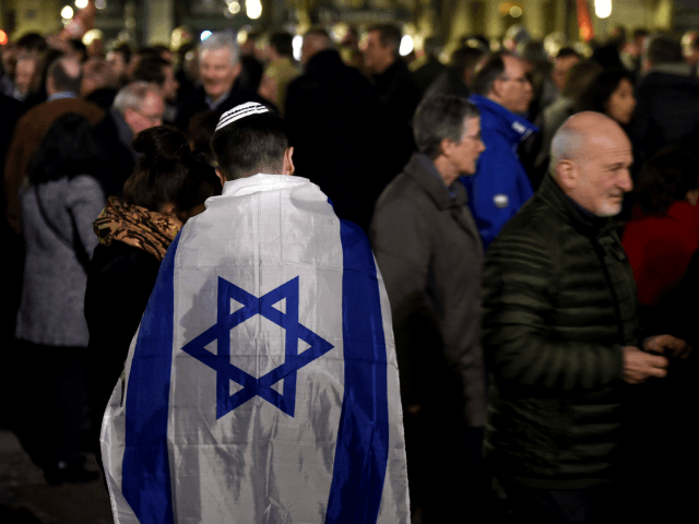 french lawmakers see A man wears an Israeli flag as he takes part in a rally against antis