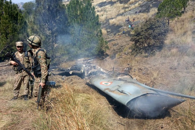 TOPSHOT - Pakistani soldiers stand next to what Pakistan says is the wreckage of an Indian fighter jet shot down in Pakistan controled Kashmir at Somani area in Bhimbar district near the Line of Control on February 27, 2019. - Pakistan said on February 27 it shot down two Indian …